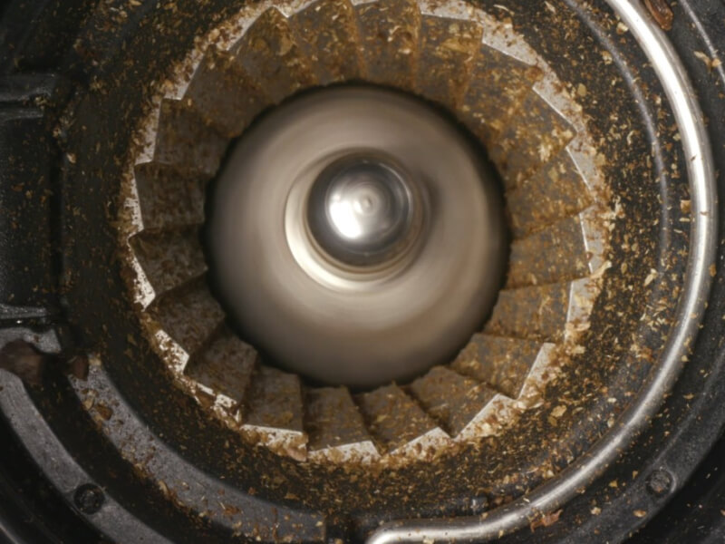 Close-up of burr grinder with remnants of coffee beans