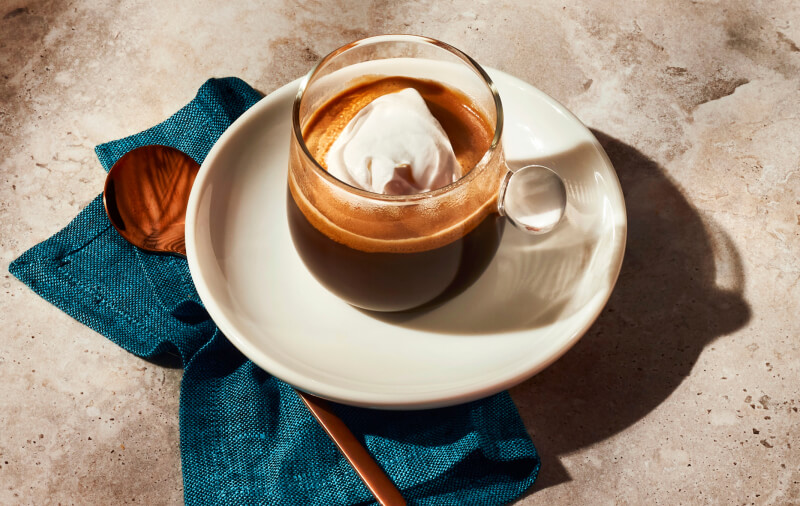 A cup of espresso topped with a scoop of vanilla ice cream.