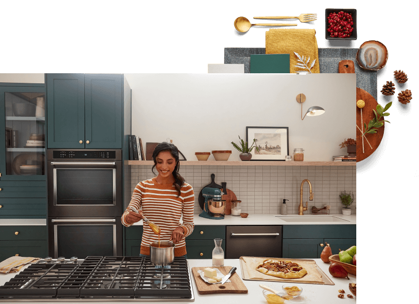 A white and rich, jewel-toned green kitchen filled with stainless steel KitchenAid® appliances.