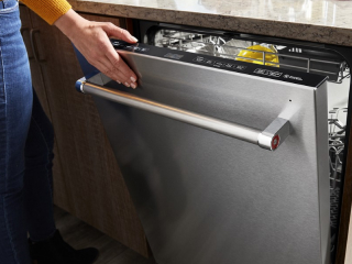 Person closing a top control dishwasher
