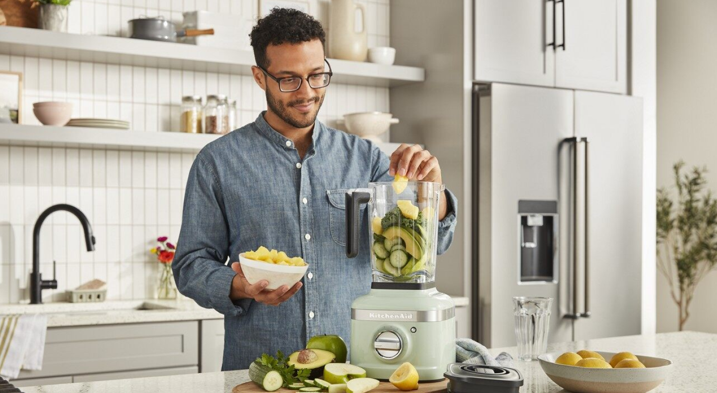 Same as Image Alt Text Person putting ingredients into KitchenAid® countertop blender