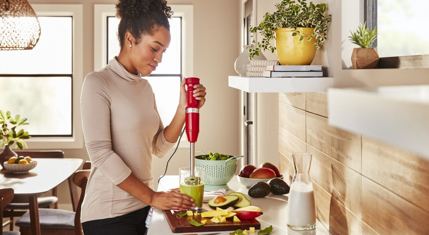 Same as Image Alt Text Person using red KitchenAid® immersion blender in cup