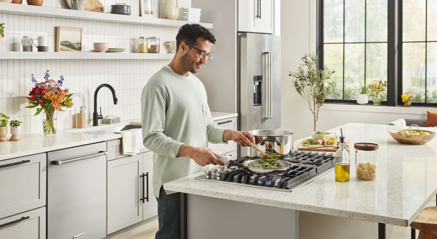 Person cooking on a gas cooktop Person cooking on a gas cooktop