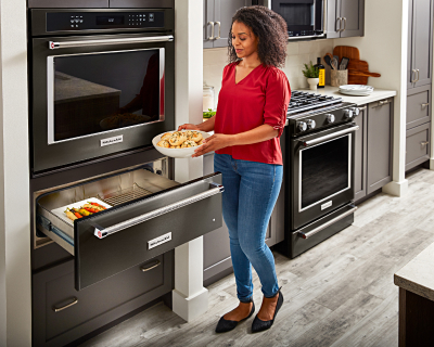 Person placing dishes in warming drawer