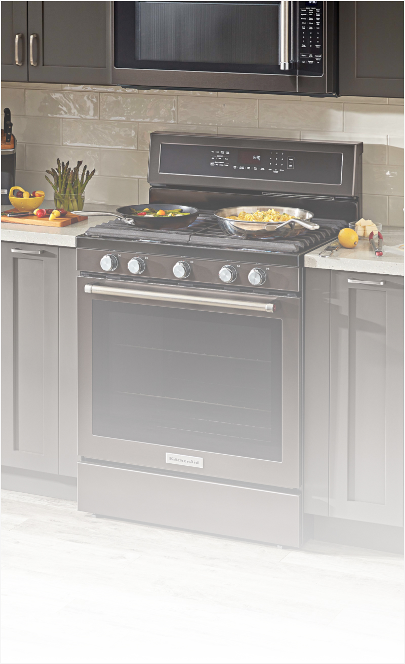 A range in a kitchen with dark cabinets