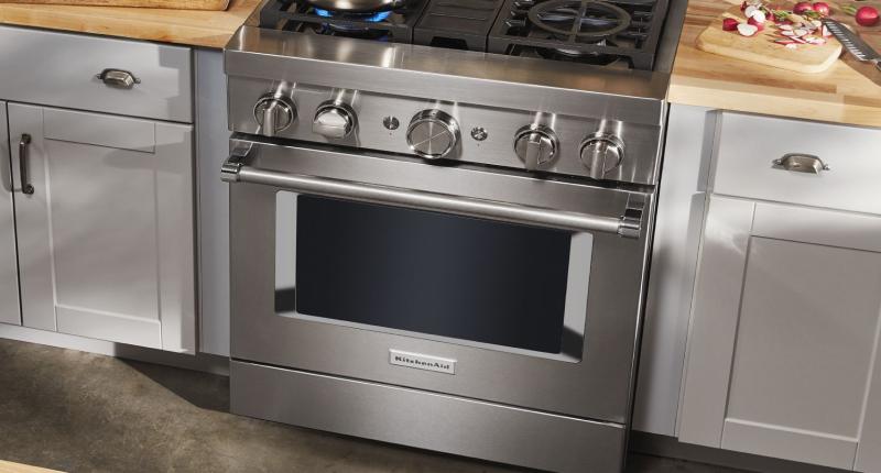 A KitchenAid® commercial-style range in a kitchen with white cabinets.