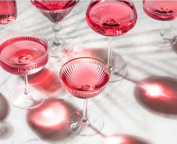 An assortment of cocktail filled with a pink beverage.