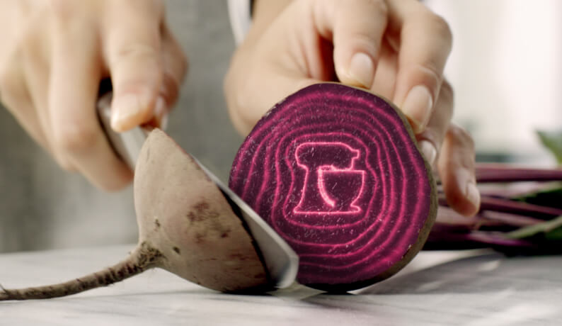 A person cutting into a beetroot.