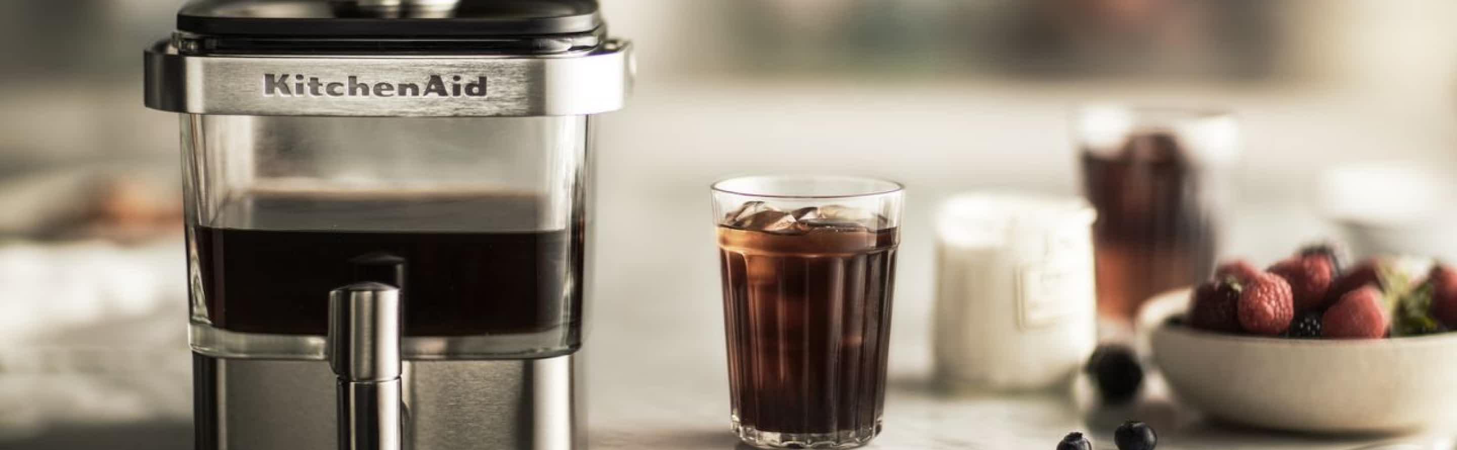 An overhead view of different KitchenAid® coffee machines, cups and beans on a counter.