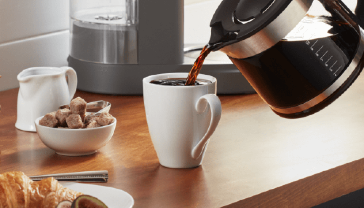 Coffee being poured into white coffee cup.