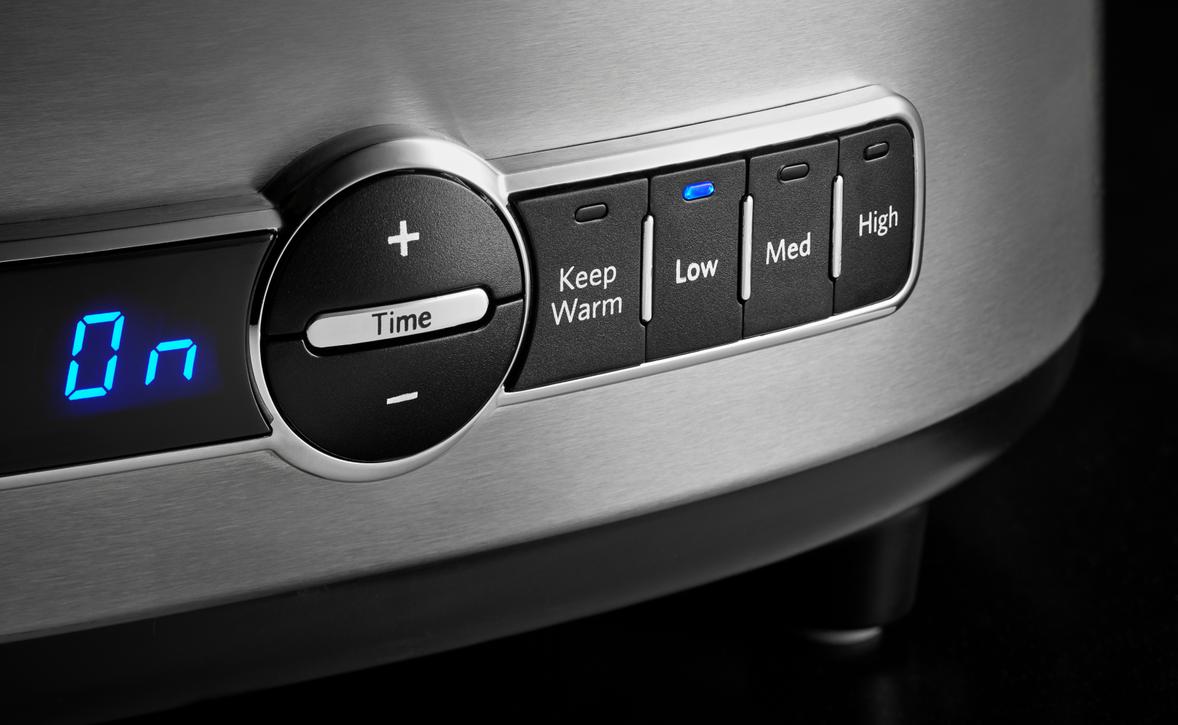 The lit up controls on a KitchenAid slow cooker.