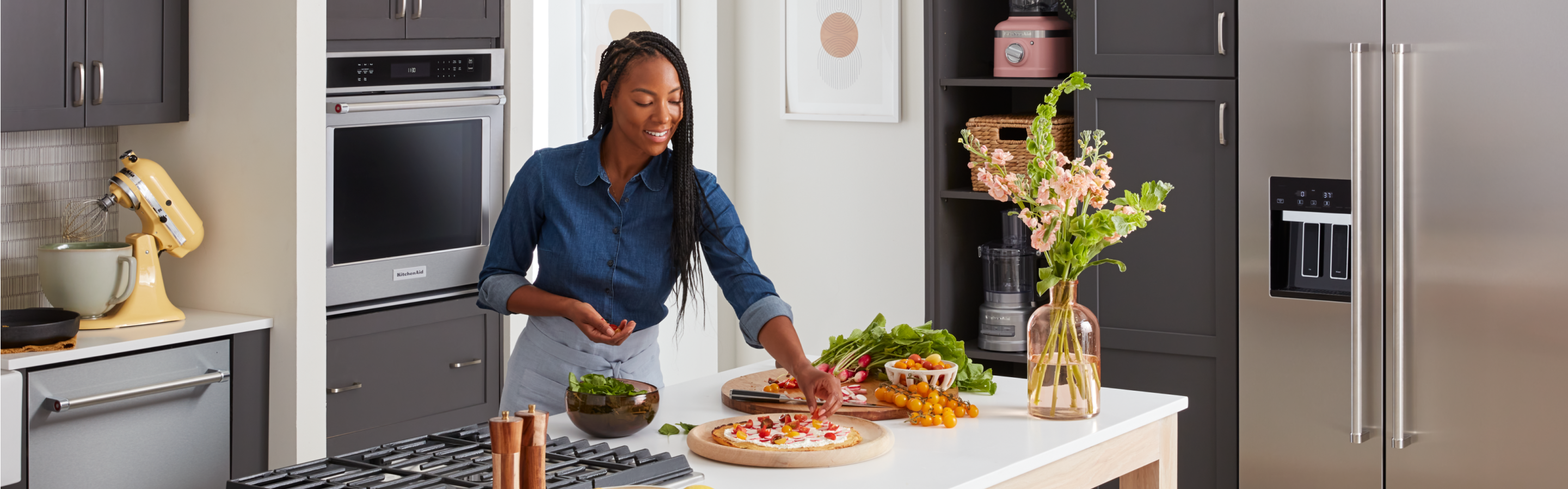 A person placing the finishing touches on cooked dishes.