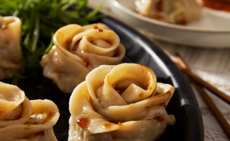 Rose-shaped gyoza dumplings on a plate.