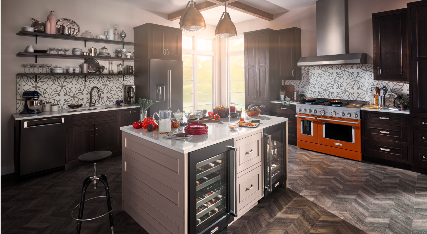A warm kitchen with herringbone tile, beige cabinets.