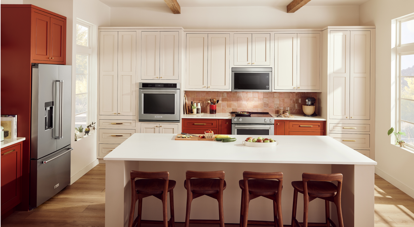 A beige kitchen with rust-colored cabinetry on one wall.