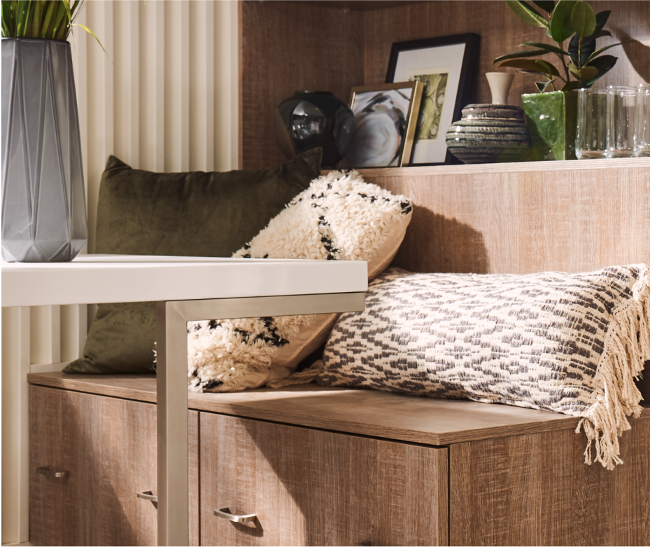 A variety of textured throw pillows on the bench seating of an eat-in kitchen.