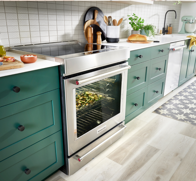 A vibrant emerald green and white kitchen featuring a KitchenAid® range.