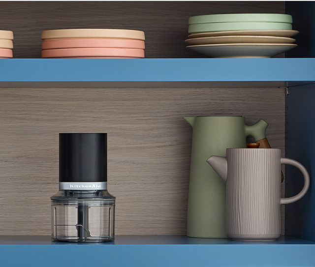 A KitchenAid® Go™ Cordless Top Down Chopper on a kitchen shelf.