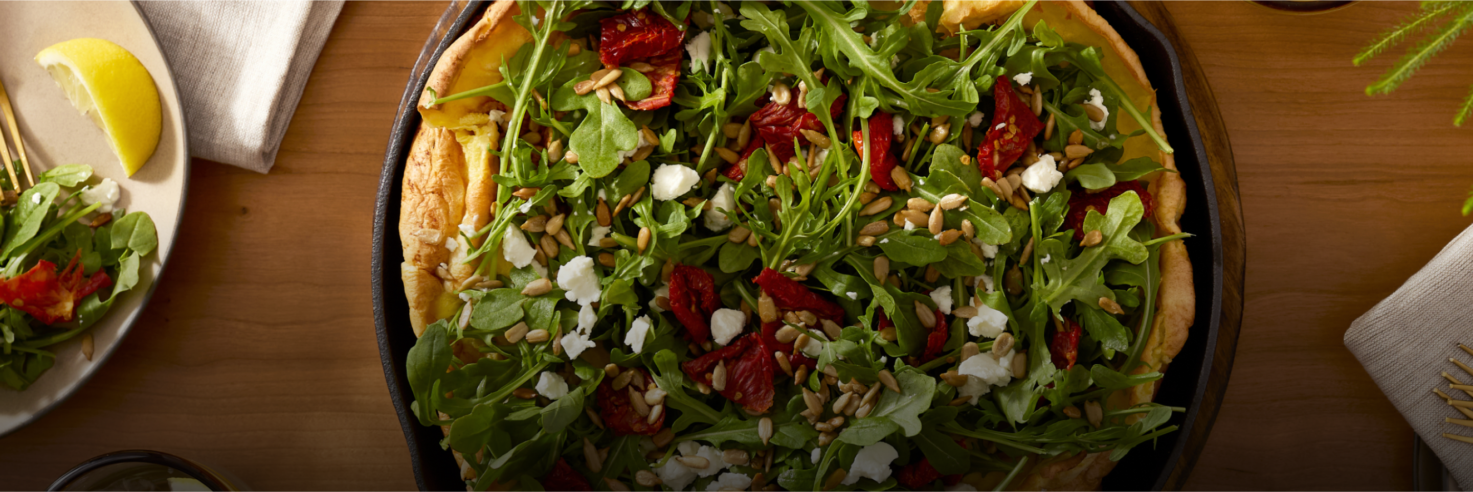 A savory dutch baby filled with a baby arugula salad.