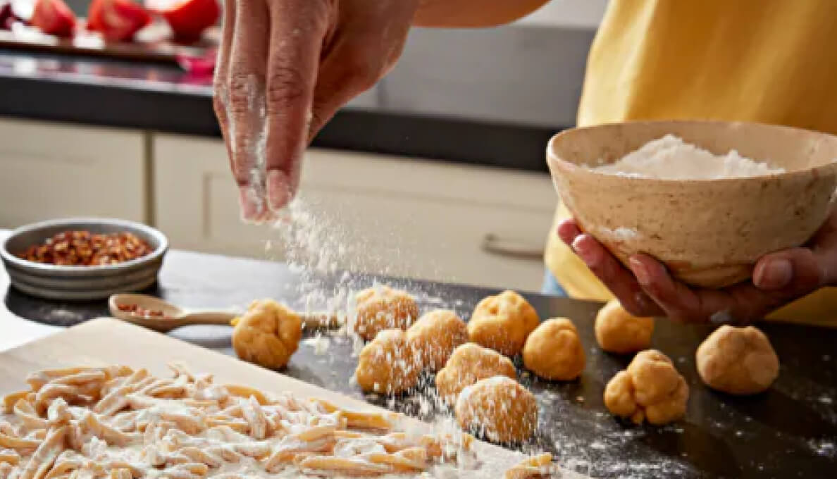 A person sprinkling flour over dough.