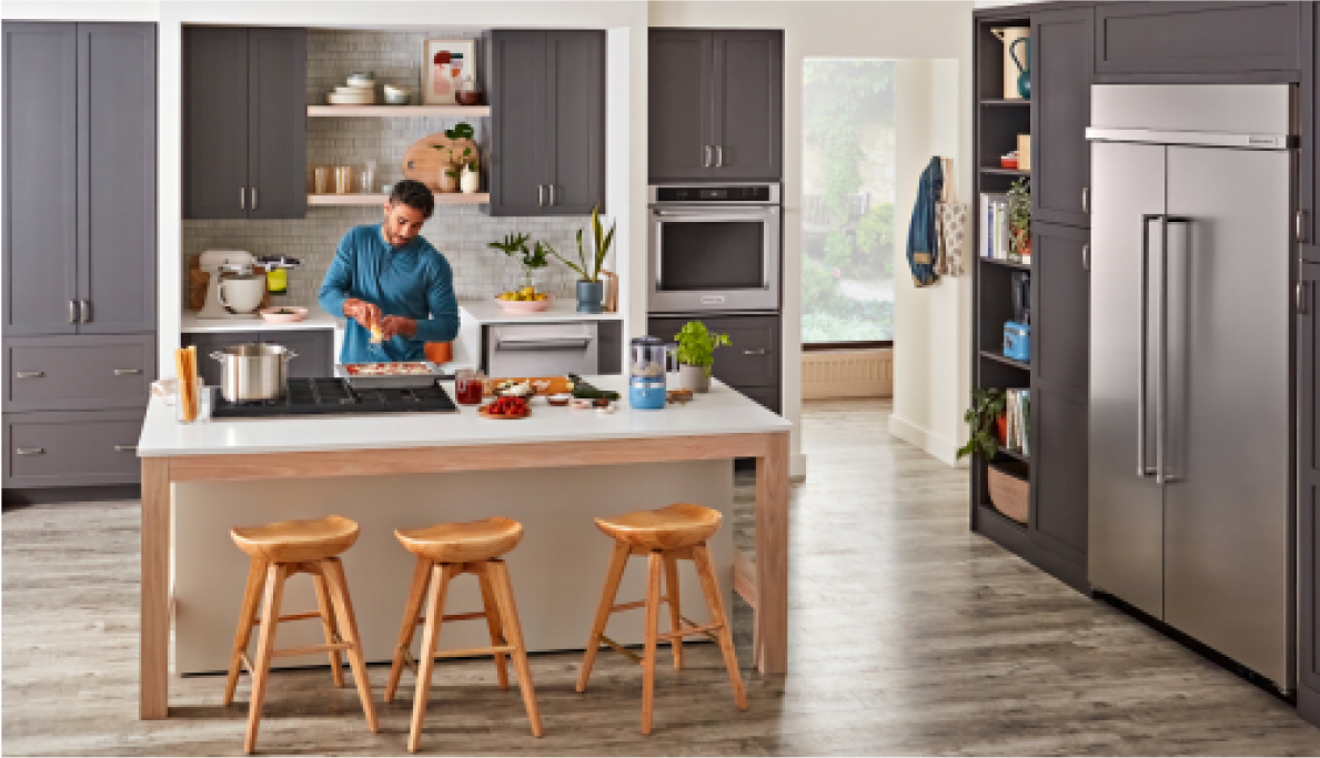 A person cooking sauce in a large modern kitchen.