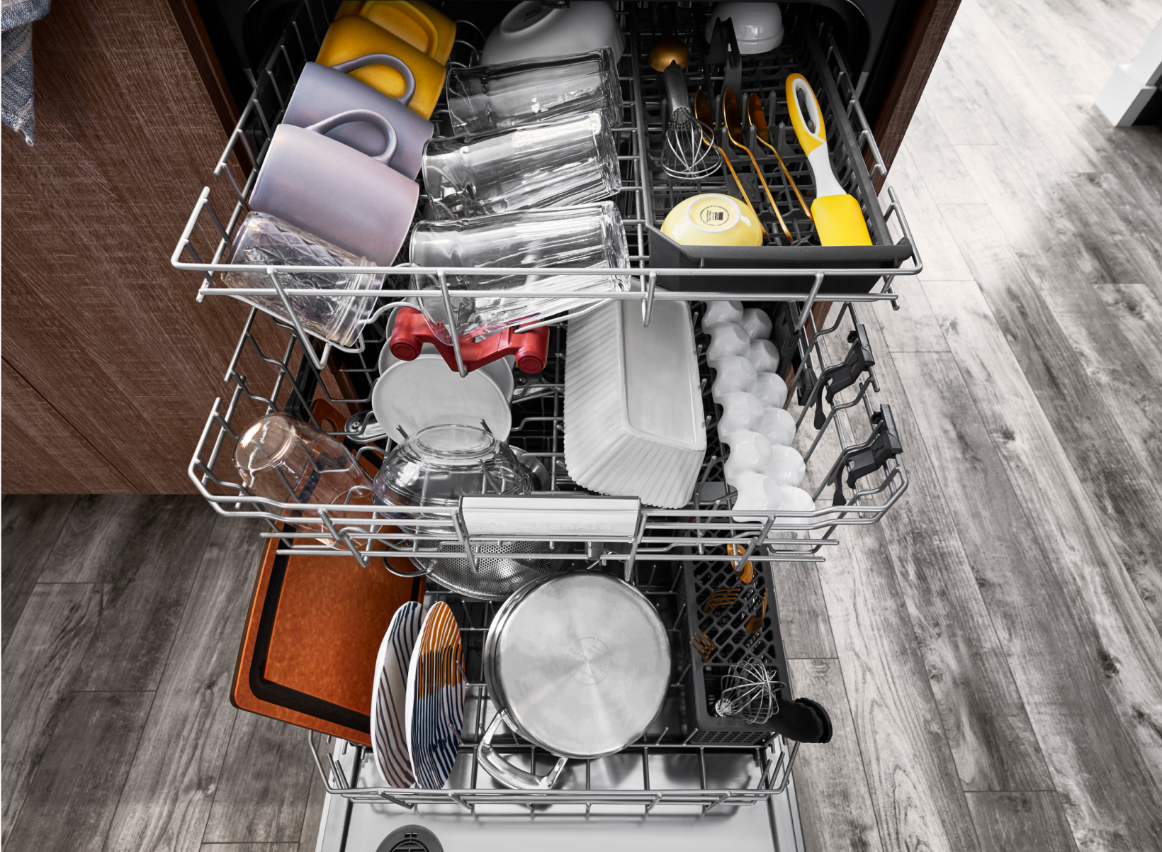 An open and loaded KitchenAid Dishwasher.