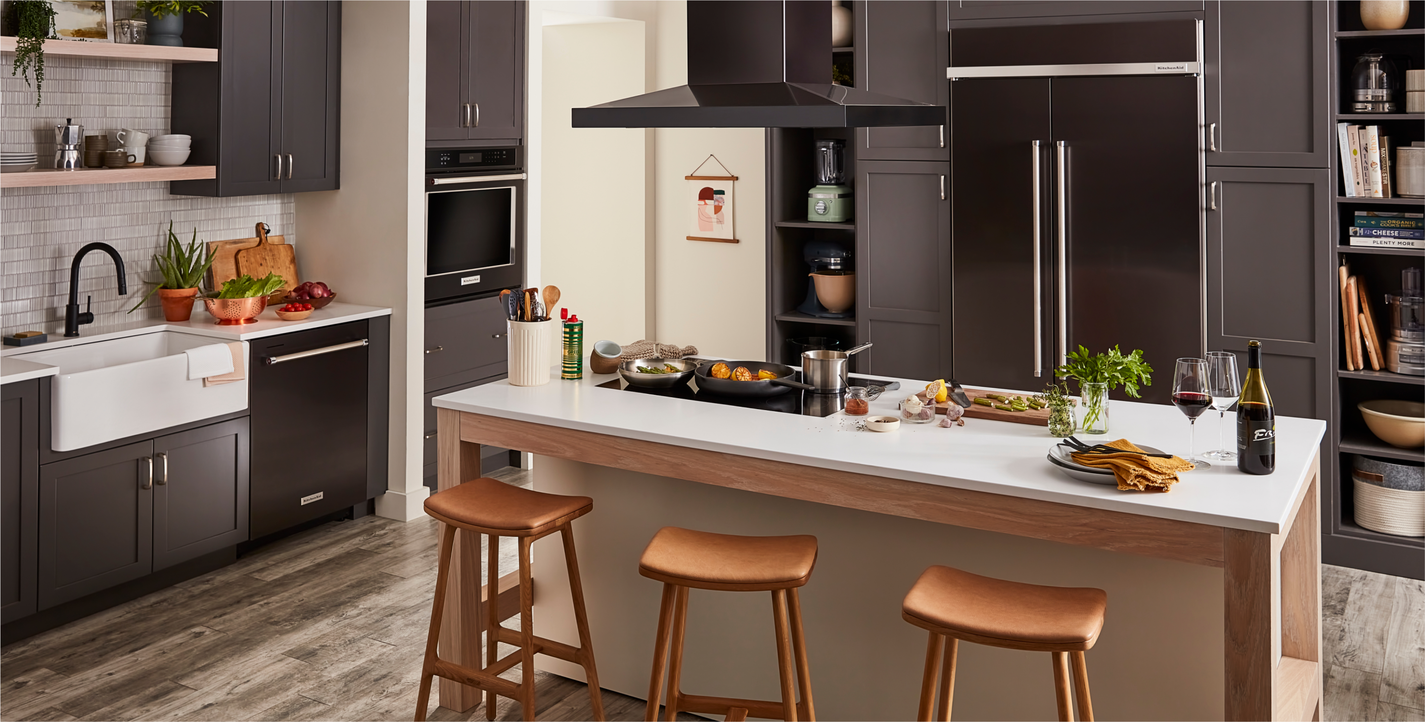 A kitchen with black cabinets and black stainless steel KitchenAid appliances.