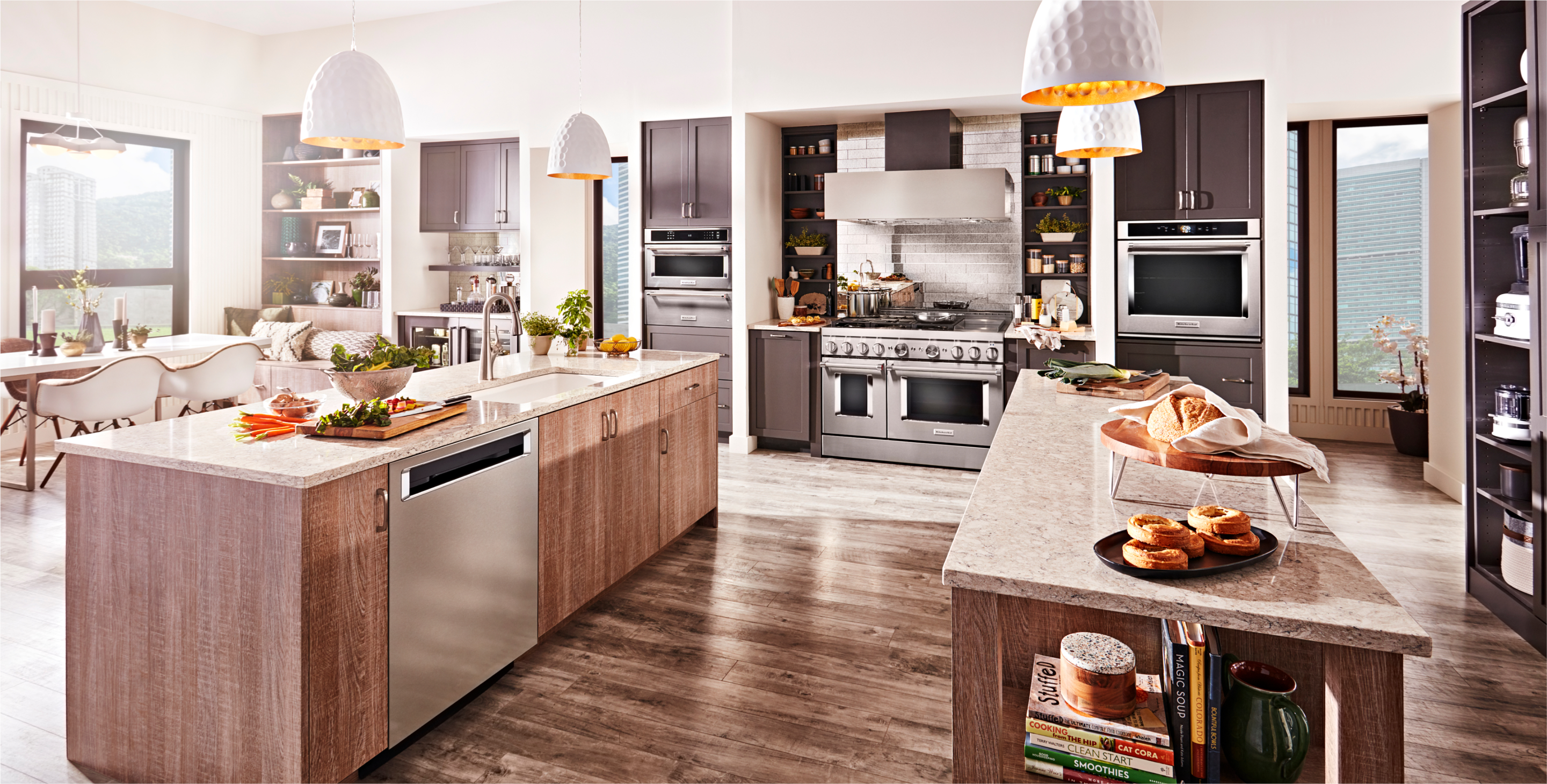 A kitchen with.light wood cabinets and stainless steel KitchenAid appliances.