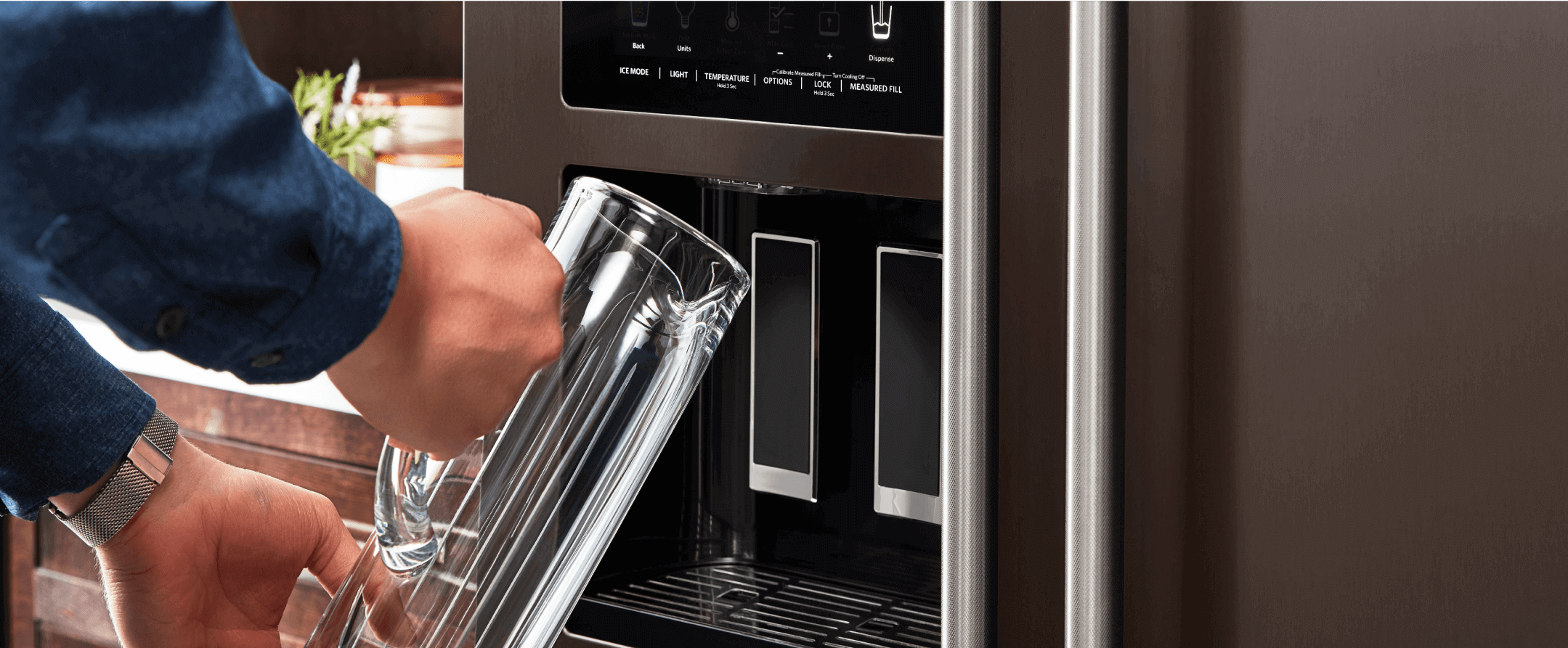 Filling a pitcher from a KitchenAid refrigerator water dispenser.