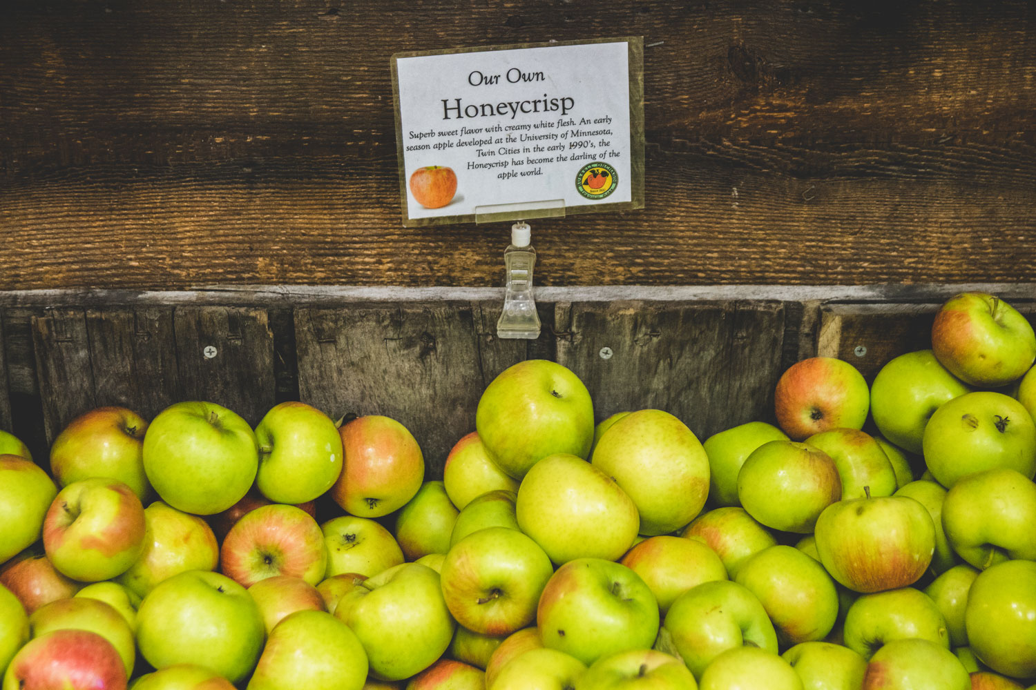 A wooden box filled with Honeycrisp apples.