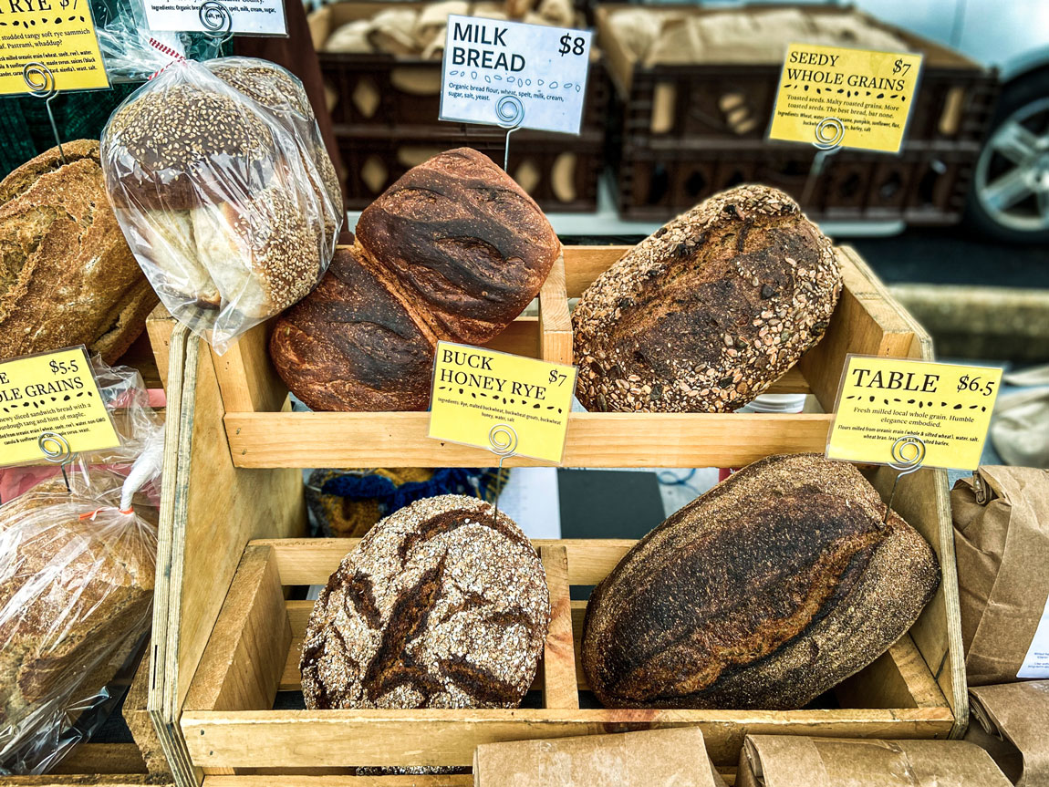 A small wooden stand filled with assorted baked bread.