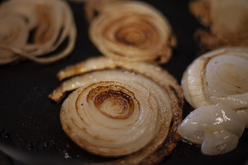 Sliced onions cooking in a skillet.