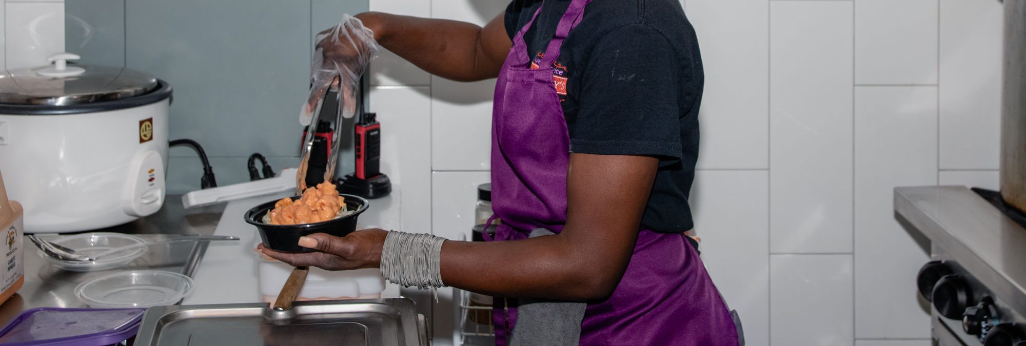 Dreamer serving food into a small container.