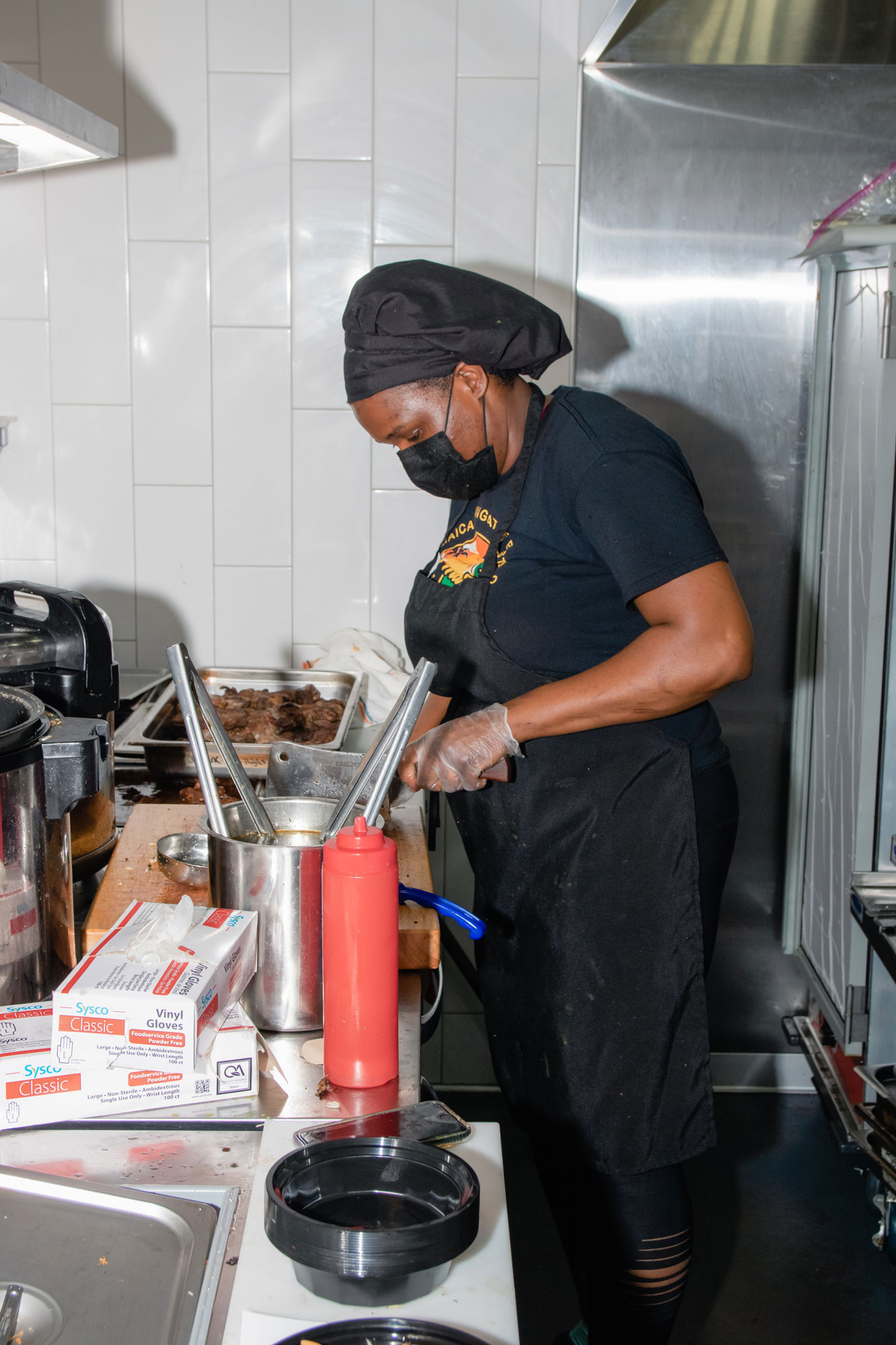 Latoya chopping meat in her kitchen.
