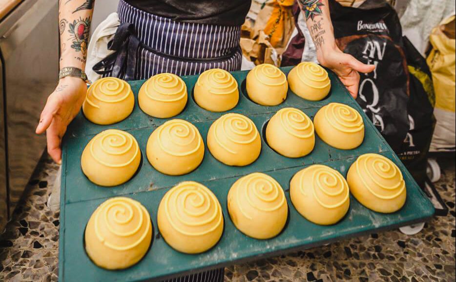 Small, delectable loaves of bread in a tray.