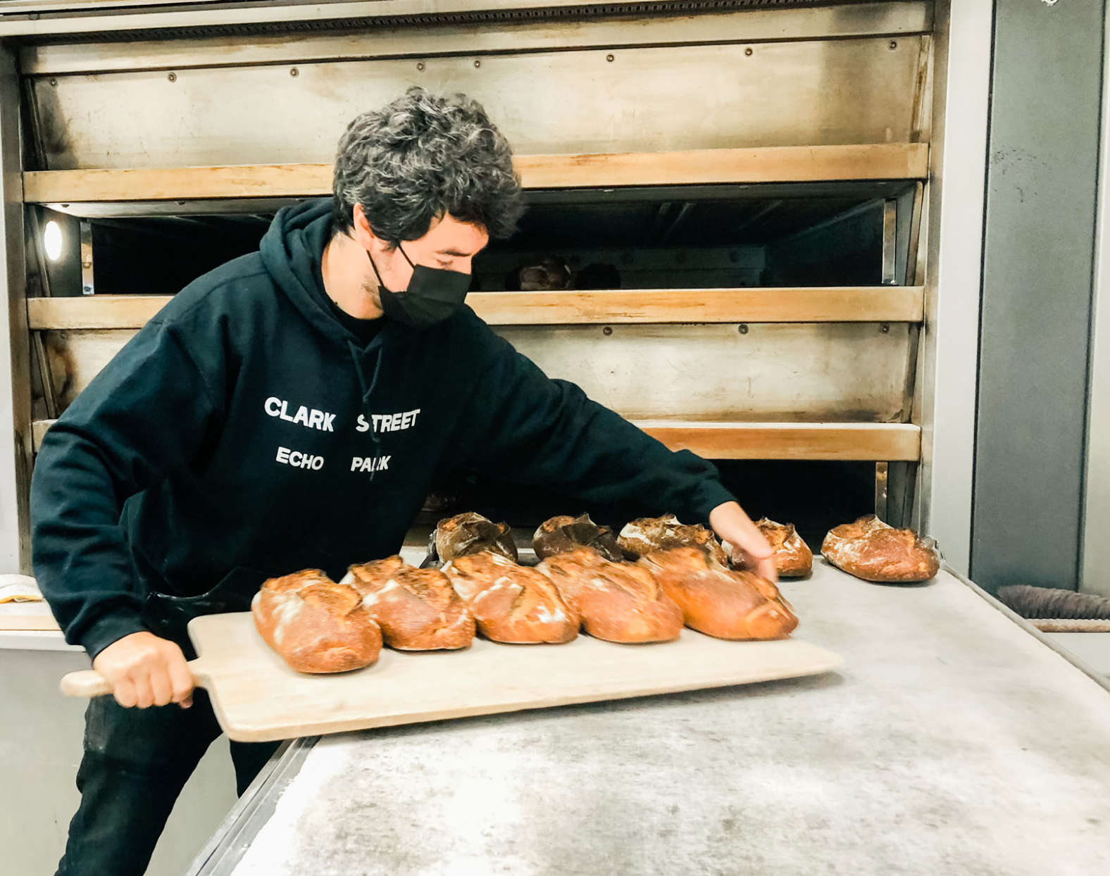 Zach Hall pulling out freshly baked bread.