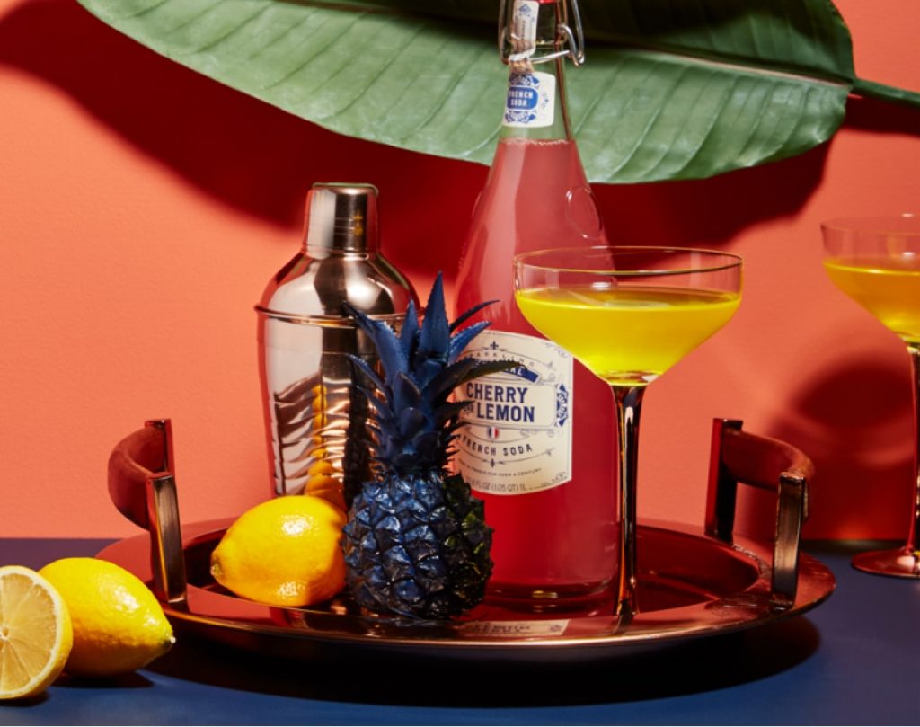 A cocktail tray with bold yellow, blue and pink ingredients.