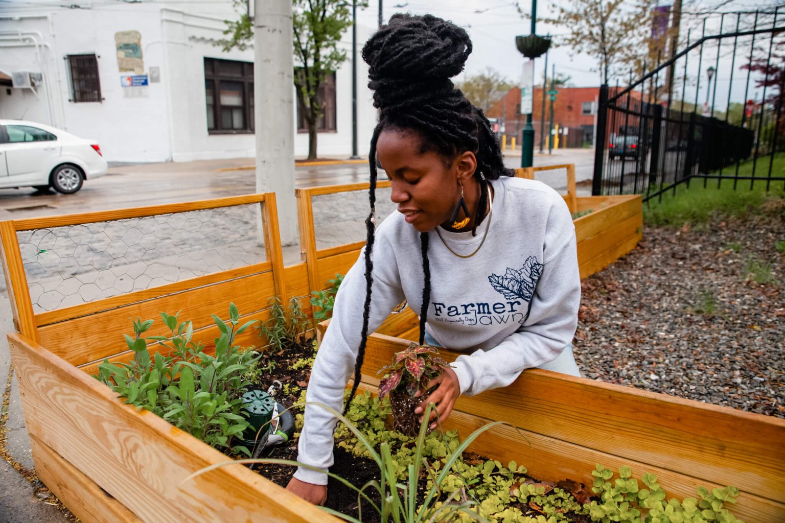 Christa planting small plants outside.