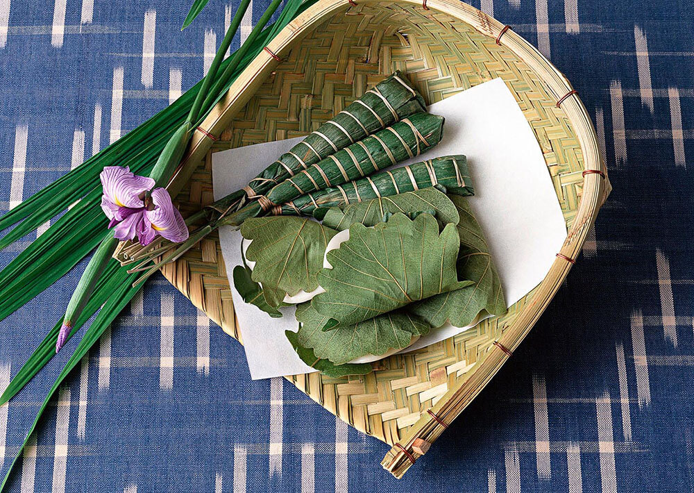 Bundles of bamboo leaves resting in a woven basket.