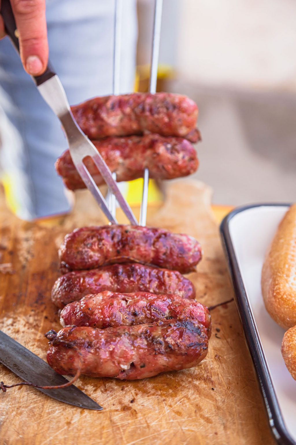 A metal skewer holding grilled sausages.
