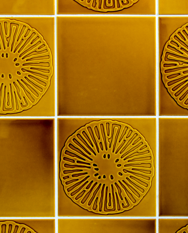 Tile with a warm color scheme and floral etched design