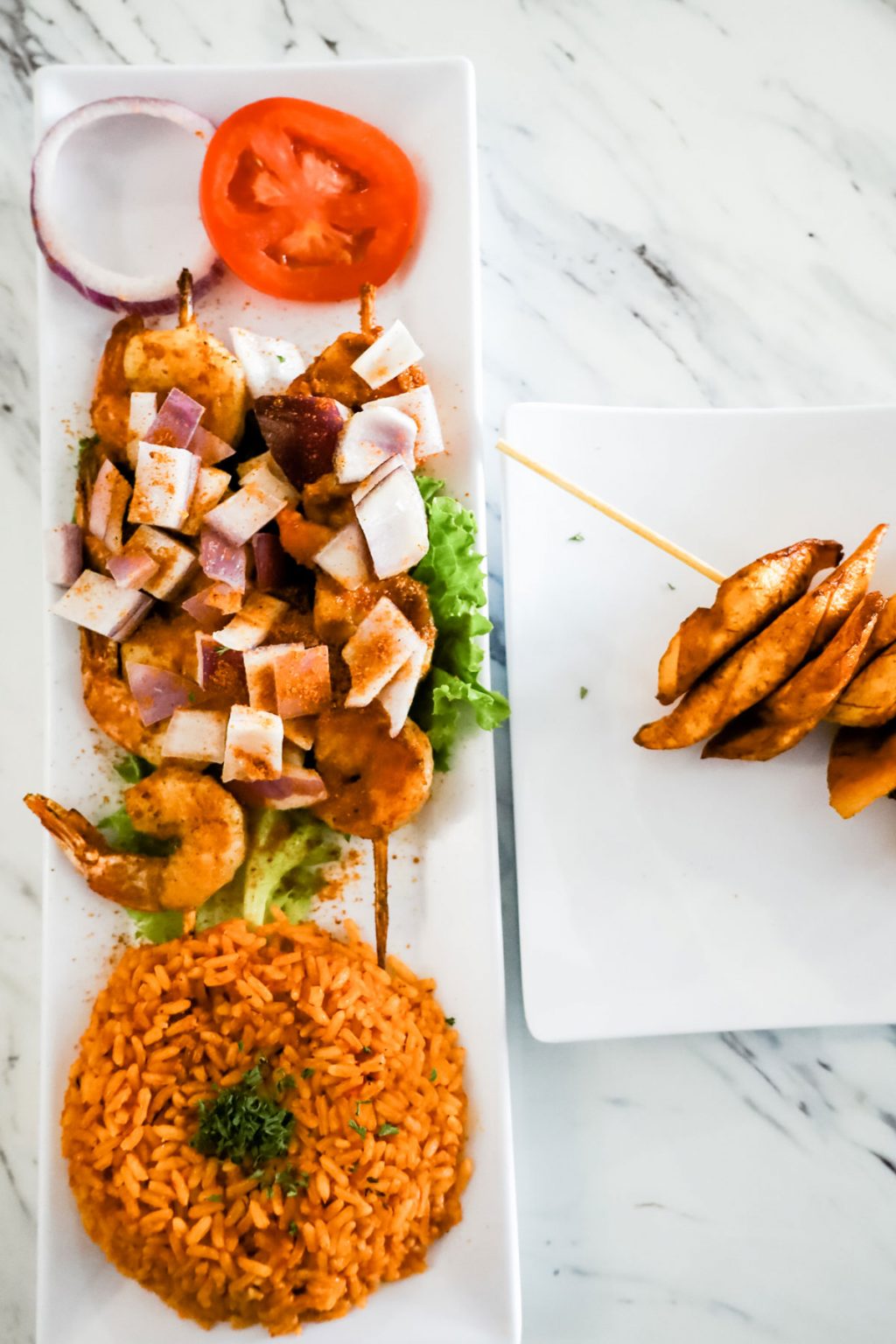 A plate of grilled shrimps on two skewers.