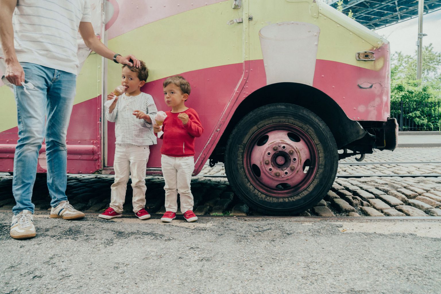 A parent and two young children enjoying their own ice cream cones.