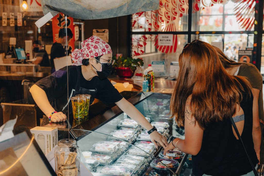 A person assisting customers over the counter.