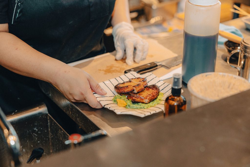 A person holding a small Japanese dish.