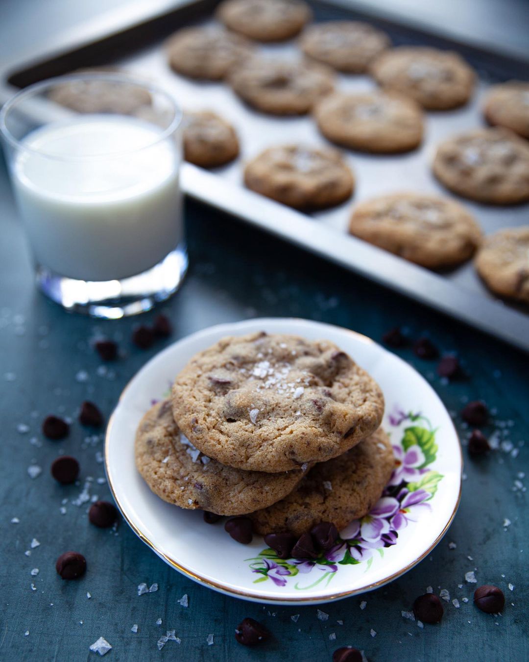 A plate of licorice cookies and a glass of milk.