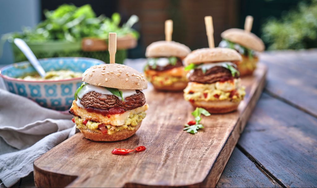 Delicate portobello mushroom burgers served on a wooden board.