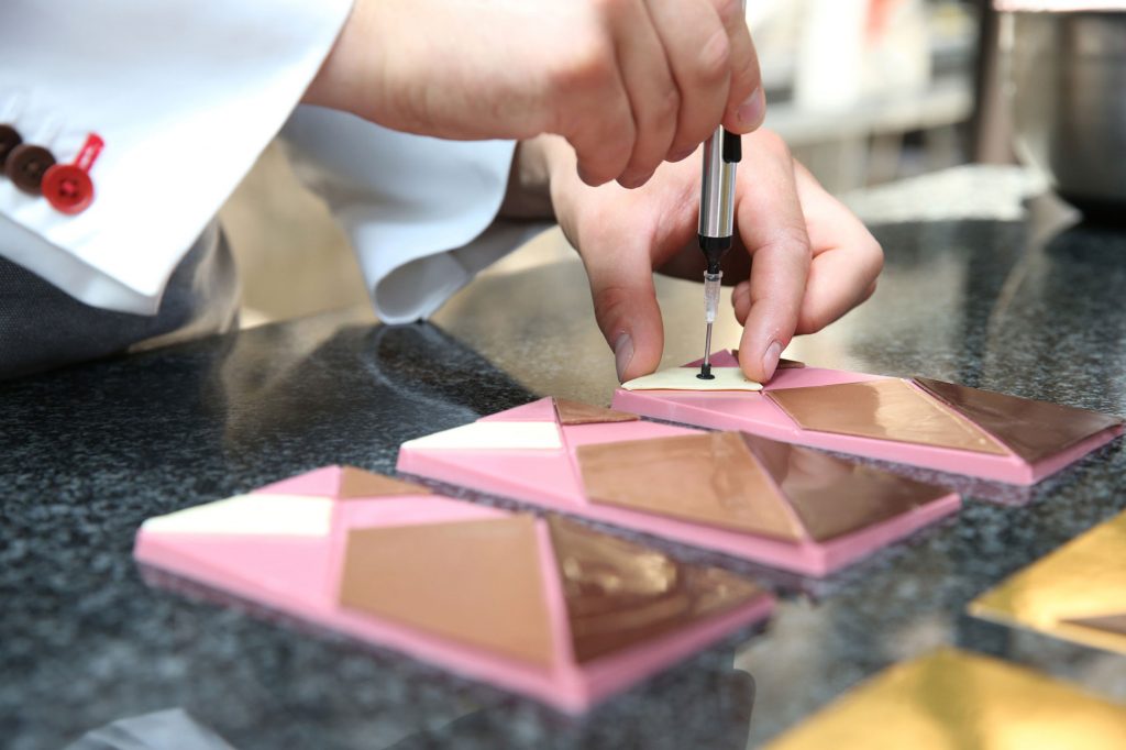 A chef putting together a four-chocolate bar.