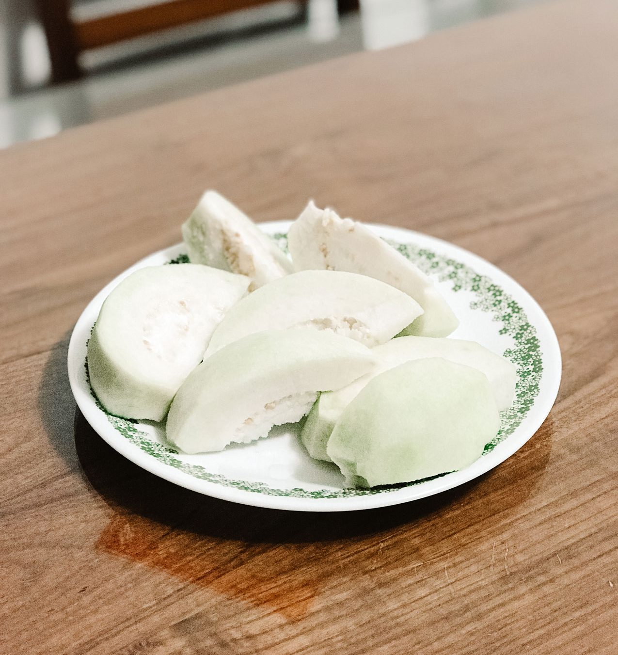 A small, delicate plate holding sliced fruit.