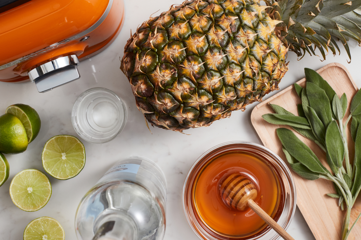 A series of ingredients, including a pineapple, honey and various herbs.